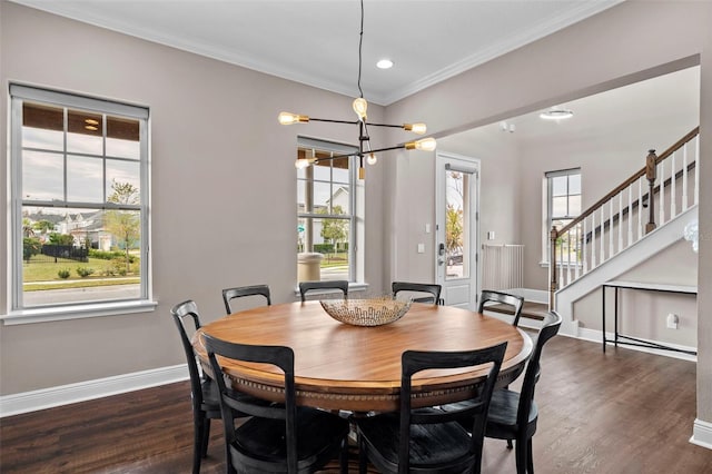 dining room with dark hardwood / wood-style flooring, crown molding, and a chandelier