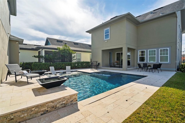 view of swimming pool with an outdoor fire pit and a patio