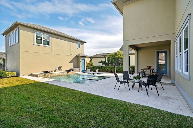 back of property with a patio area and a yard