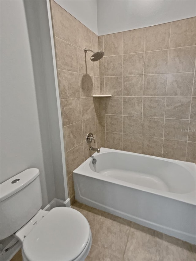 bathroom with tiled shower / bath, tile patterned floors, and toilet