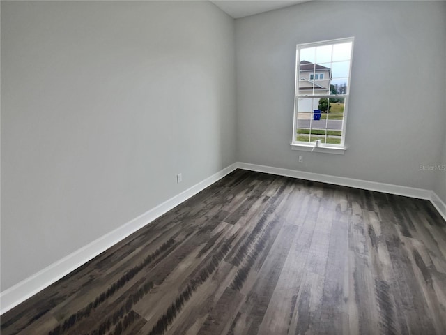 empty room featuring a healthy amount of sunlight and dark hardwood / wood-style floors