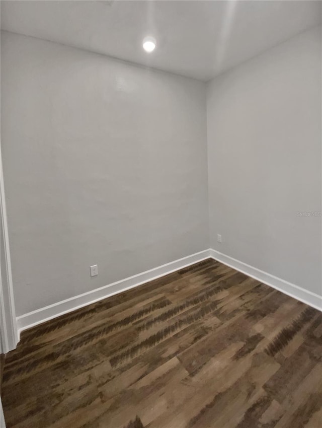 unfurnished room with dark wood-type flooring