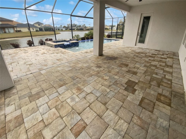 view of patio featuring a water view, pool water feature, a swimming pool with hot tub, and a lanai