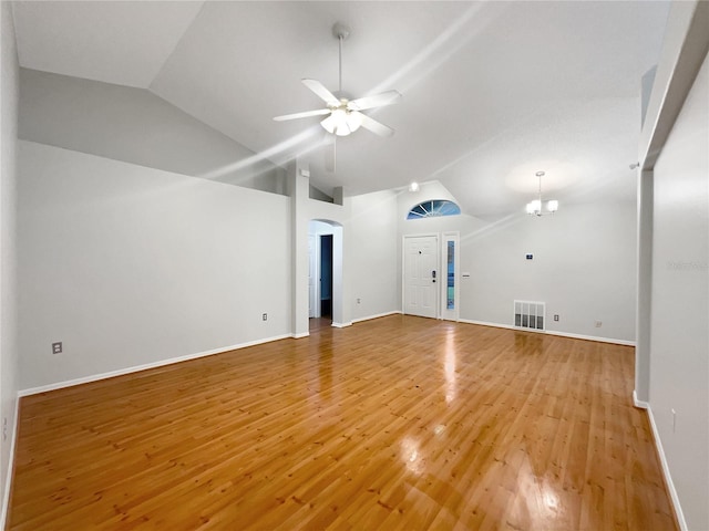 unfurnished living room with ceiling fan with notable chandelier, vaulted ceiling, and hardwood / wood-style flooring