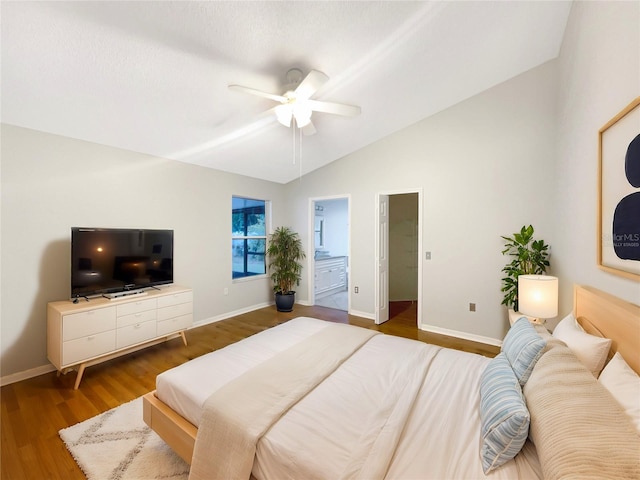 bedroom featuring ensuite bath, vaulted ceiling, dark hardwood / wood-style floors, and ceiling fan