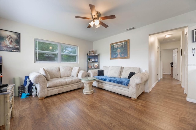 living room with ceiling fan and light wood-type flooring