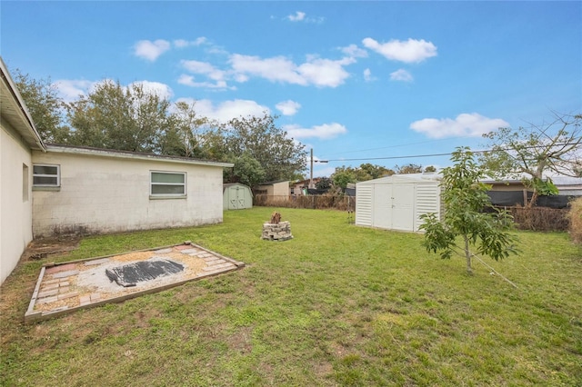 view of yard featuring a storage unit and an outdoor fire pit