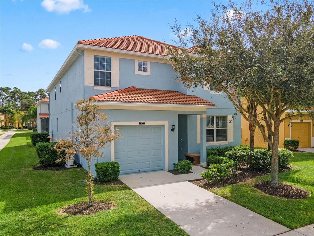 mediterranean / spanish-style house featuring a garage and a front yard