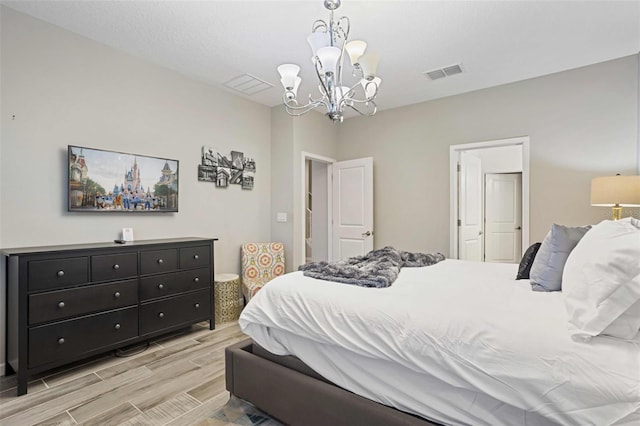 bedroom with a chandelier and light wood-type flooring