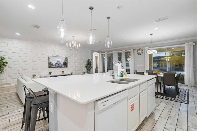 kitchen with white cabinetry, a kitchen island with sink, sink, and white dishwasher