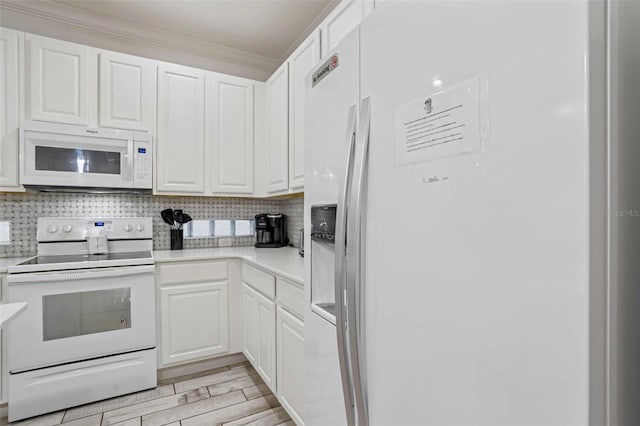 kitchen with backsplash, white appliances, ornamental molding, and white cabinets