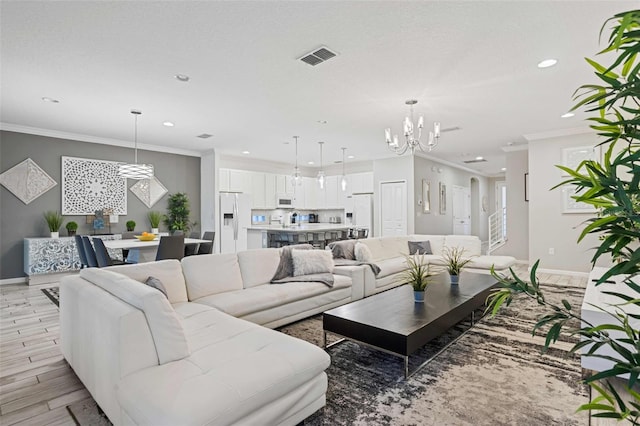 living room with crown molding and a chandelier