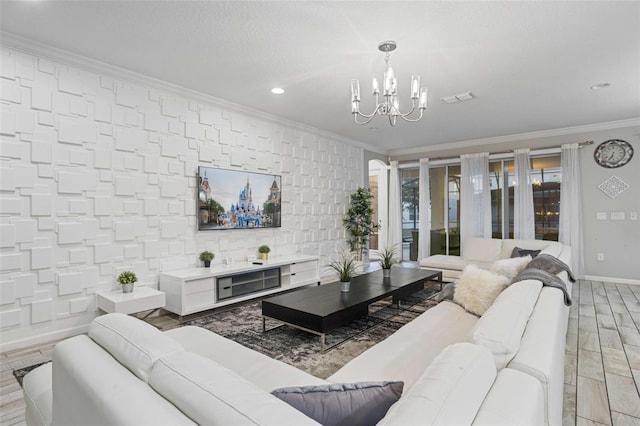 living room with crown molding, a chandelier, and light hardwood / wood-style floors