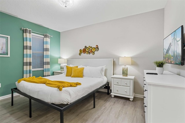 bedroom with wood-type flooring and a textured ceiling