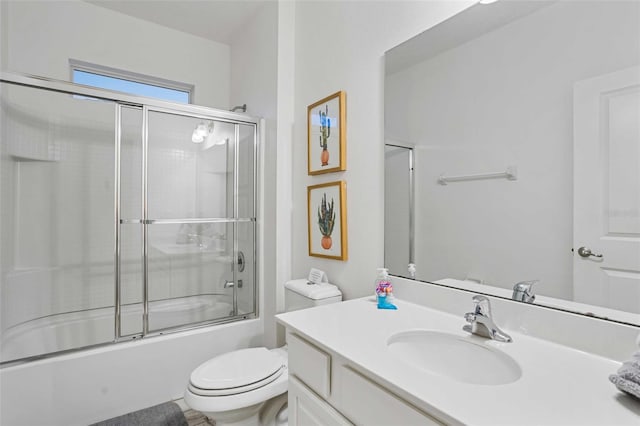 full bathroom featuring enclosed tub / shower combo, vanity, and toilet