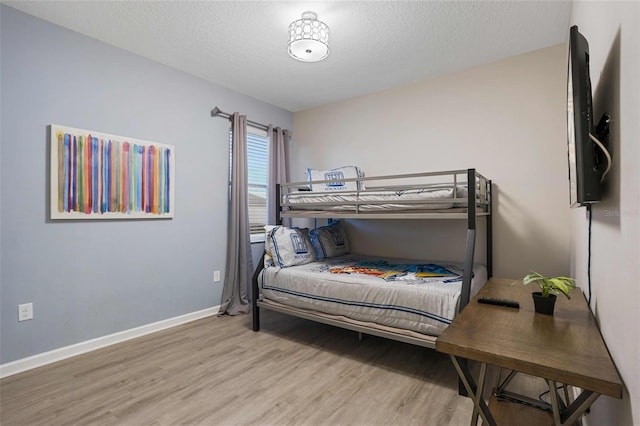 bedroom featuring light hardwood / wood-style floors and a textured ceiling