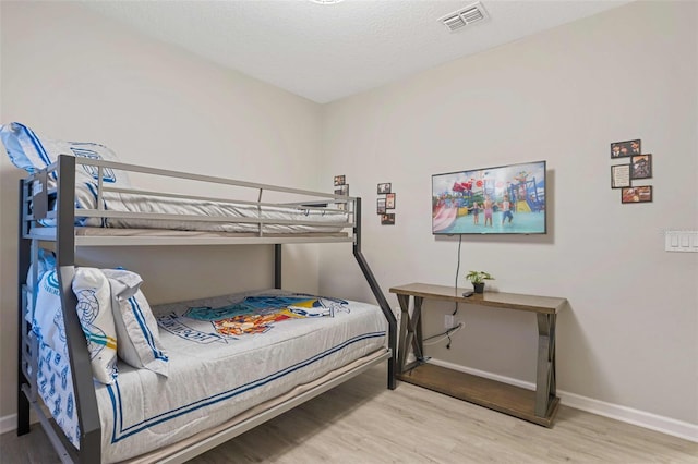 bedroom with hardwood / wood-style floors and a textured ceiling