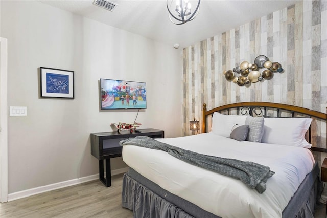 bedroom with a notable chandelier and hardwood / wood-style flooring