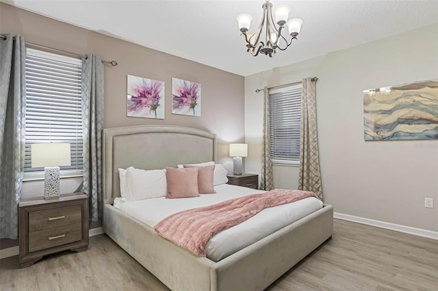 bedroom with a notable chandelier and light hardwood / wood-style floors