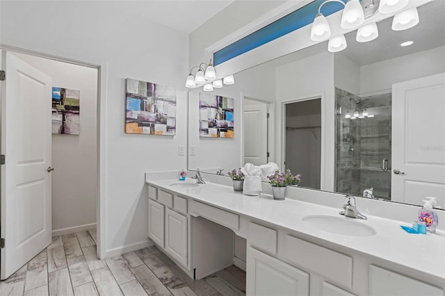 bathroom with hardwood / wood-style flooring, vanity, a notable chandelier, and a shower with shower door