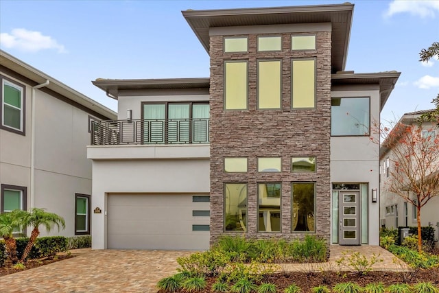 contemporary home with a garage and a balcony