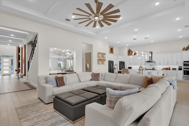 living room featuring beamed ceiling and light wood-type flooring