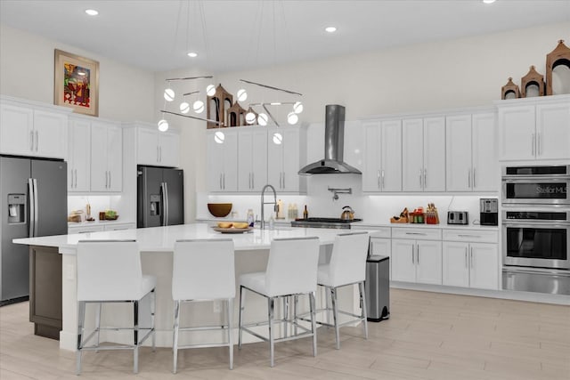 kitchen with stainless steel appliances, white cabinetry, and a kitchen island with sink