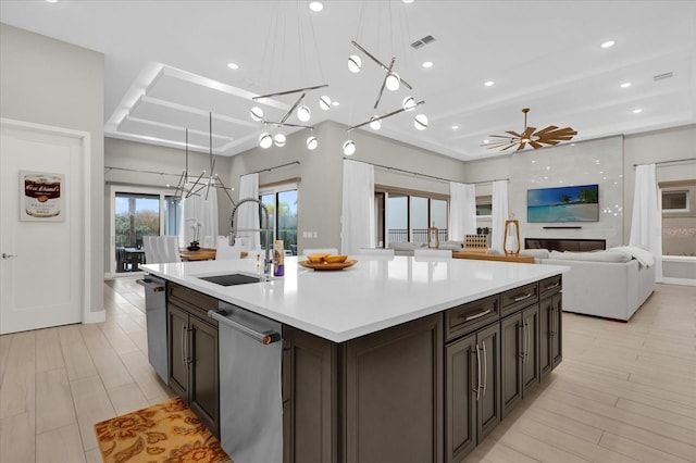 kitchen featuring a large island, sink, pendant lighting, dishwasher, and dark brown cabinets