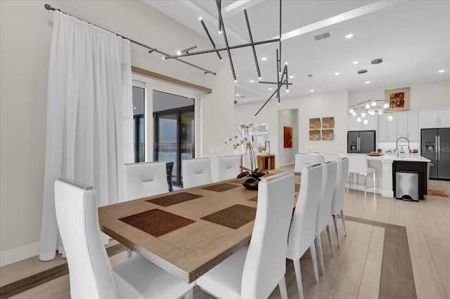 dining area with sink and light wood-type flooring