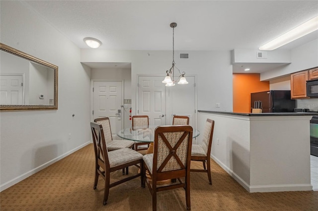 carpeted dining area featuring a chandelier