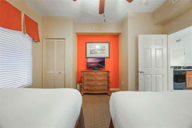 carpeted bedroom with a closet, ceiling fan, and multiple windows