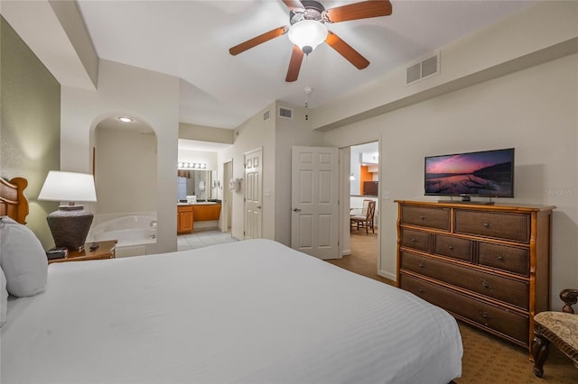 bedroom featuring ceiling fan, light carpet, and ensuite bath