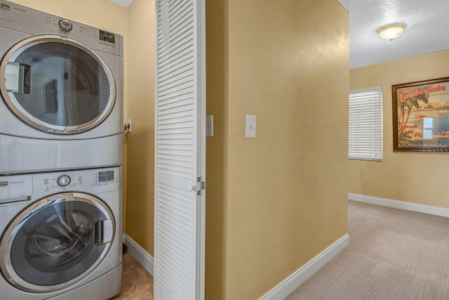 laundry room with a textured ceiling and stacked washer / dryer