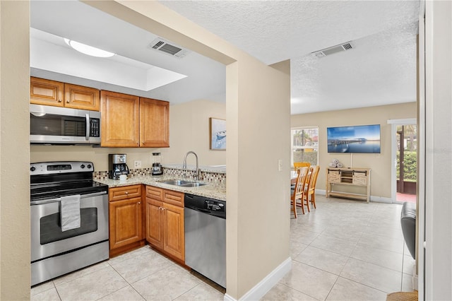 kitchen with stainless steel appliances, visible vents, a sink, and light tile patterned floors