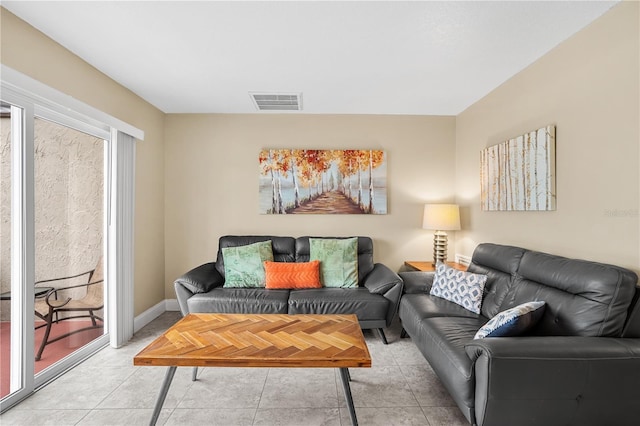 living room with light tile patterned floors, baseboards, and visible vents