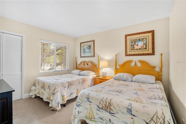 carpeted bedroom with a closet and baseboards