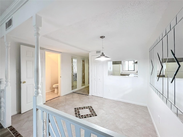 interior space featuring a wealth of natural light, a textured ceiling, and light tile patterned flooring