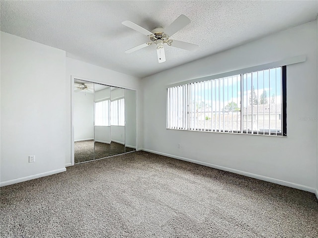 carpeted spare room with ceiling fan and a textured ceiling