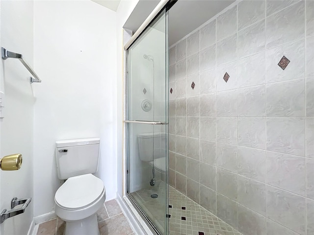 bathroom featuring a shower with shower door, toilet, and tile patterned flooring