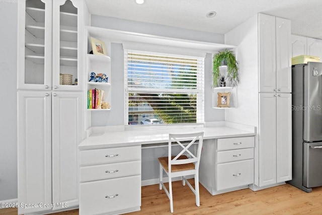 office space featuring light hardwood / wood-style flooring and built in desk