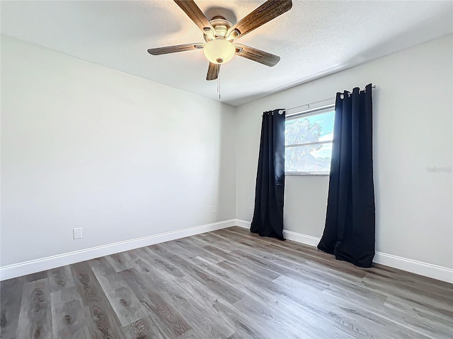 spare room with hardwood / wood-style floors, a textured ceiling, and ceiling fan