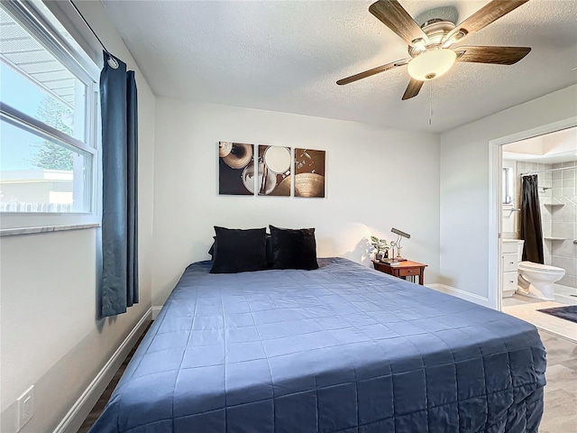 bedroom with connected bathroom, a textured ceiling, wood-type flooring, and ceiling fan