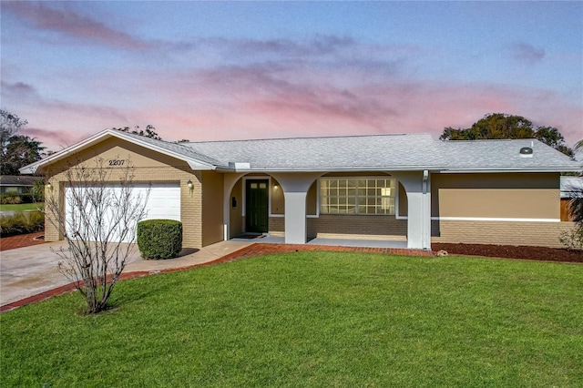 ranch-style home with a yard and a garage