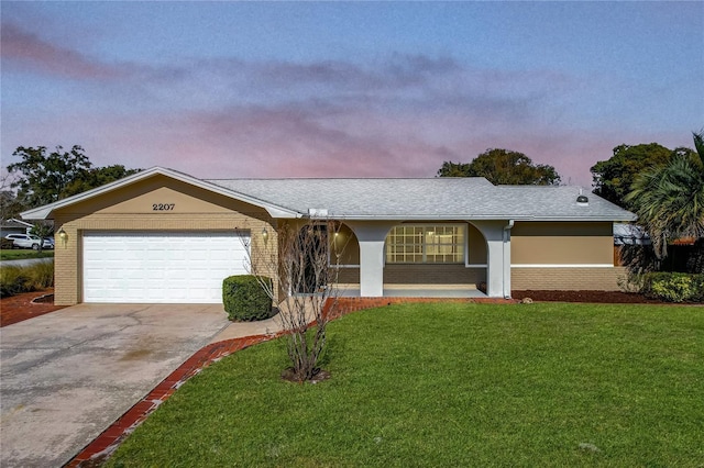 ranch-style house with a garage and a yard