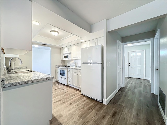 kitchen featuring sink, hardwood / wood-style floors, white cabinets, and white appliances