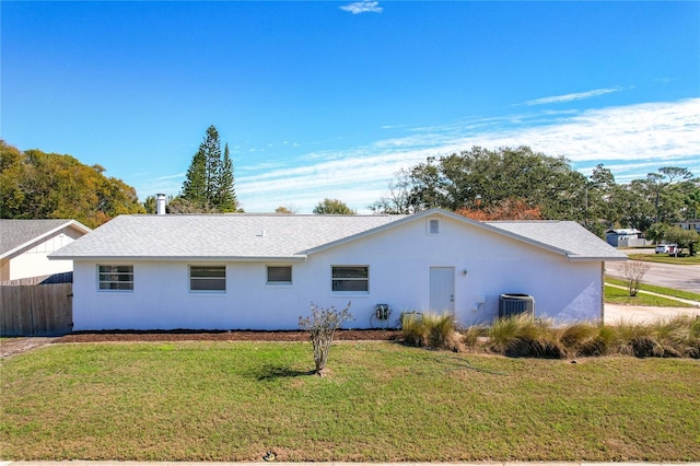 back of property featuring central AC unit and a lawn