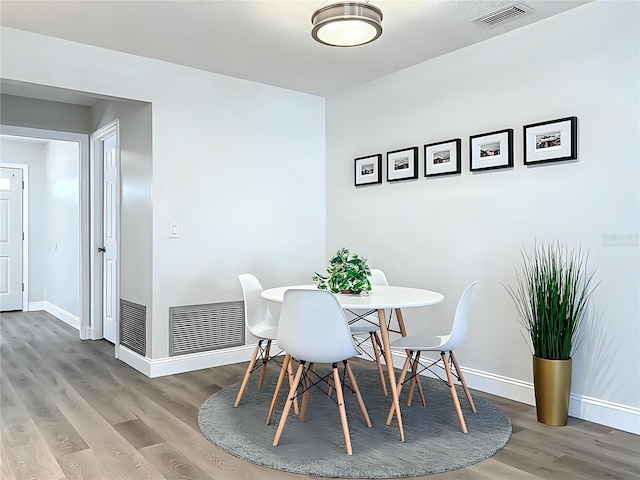 dining space with visible vents, baseboards, and wood finished floors