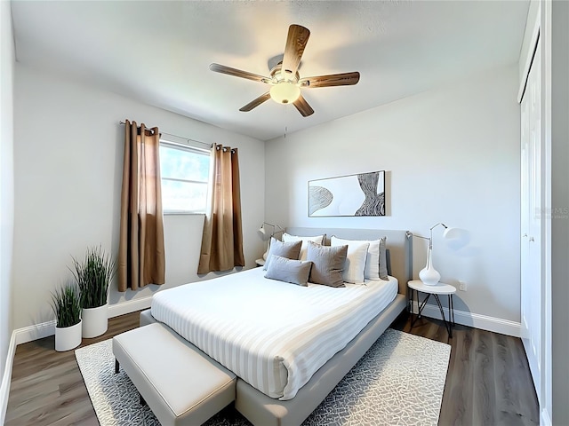 bedroom featuring ceiling fan, wood finished floors, and baseboards