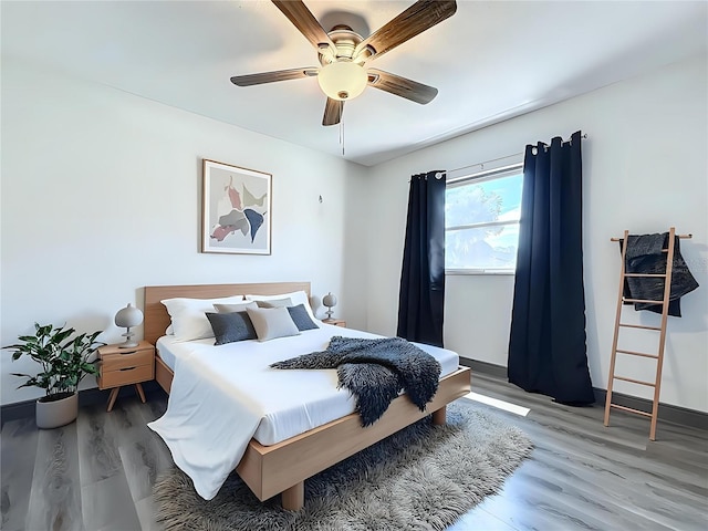 bedroom with baseboards, a ceiling fan, and light wood-style floors