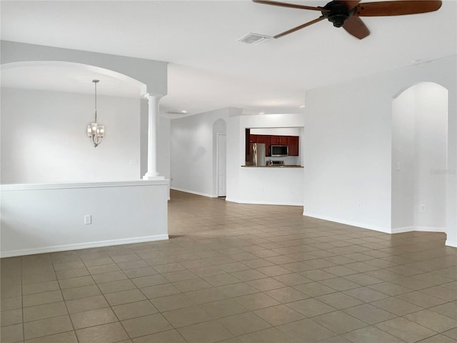 spare room featuring dark tile patterned flooring, ceiling fan, and ornate columns